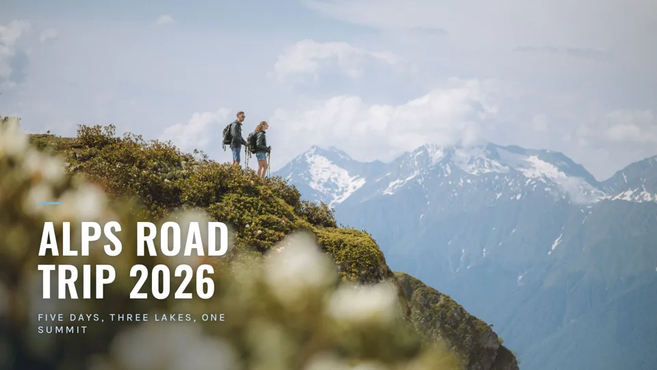 Two hikers on a grassy ridge above snowy Alpine peaks, under the title Alps Road Trip 2026